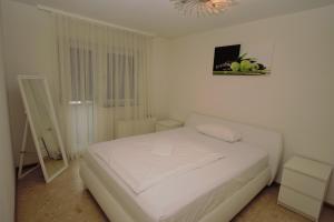 una camera bianca con un letto bianco e un lampadario a braccio di Luxury Apartment in Stuttgart a Stoccarda