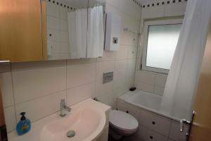 een badkamer met een wastafel, een toilet en een raam bij Luxury Apartment in Stuttgart in Stuttgart