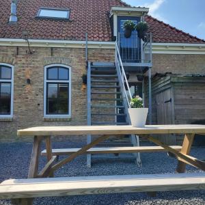- une table de pique-nique en bois devant une maison dans l'établissement In de Boerderij, à Arum