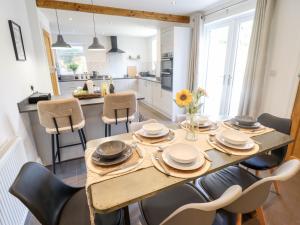 a kitchen and dining room with a wooden table and chairs at Rose Dene in Brough