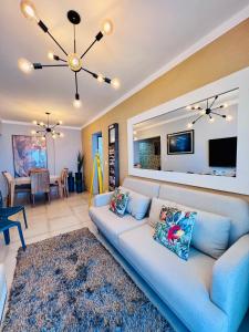un salon avec un canapé bleu et une télévision dans l'établissement AP alto padrão, frente mar panorâmico., à Praia Grande