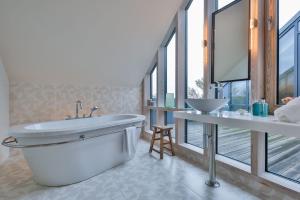 a bathroom with a large tub and a sink at Kontorhaus Keitum in Keitum