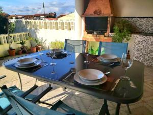a table with plates and wine glasses on a patio at Casa Alegria - The Orangery 