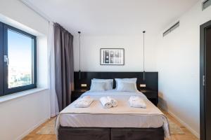 a bedroom with a large bed with two towels on it at Miramare Hotel in Zadar