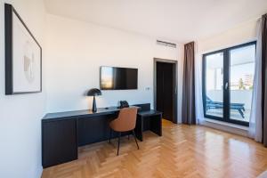a room with a desk with a chair and a window at Miramare Hotel in Zadar