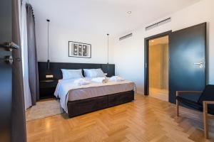 a bedroom with a bed with a cat sitting on it at Miramare Hotel in Zadar