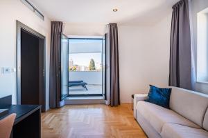a living room with a couch and a large window at Miramare Hotel in Zadar