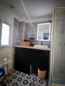 a bathroom with a sink and a mirror at Le Loge'Mans Appartement proche gare , Tram et centre ville in Le Mans