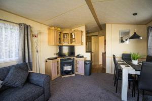 ein Wohnzimmer mit einem Sofa und einem Tisch in einem Wohnwagen in der Unterkunft 8 Berth Caravan For Hire At Breydon Water Holiday Park In Norfolk Ref 10029rp in Belton