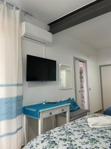 a bedroom with a bed and a desk with a tv at Affittacamere Il Vicoletto Aria Ona in Villagrande Strisaili +60 photos