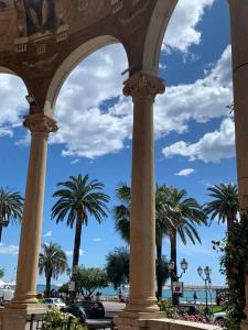 a row of columns with palm trees in the background at Hotel Fernanda in Rapallo