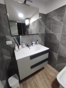 La salle de bains est pourvue d'un lavabo blanc et d'un miroir. dans l'établissement Grandmother's house, à Naples