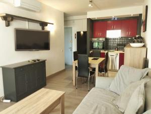 uma sala de estar com um sofá e uma cozinha com armários vermelhos em Casa de la Mama em Parque Holandes