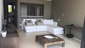 a living room with a white couch and a table at Hotel Mediterraneo Suite&Residence in Lido di Jesolo