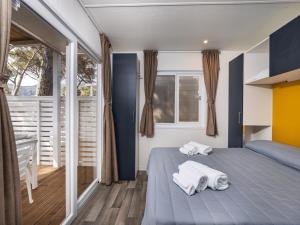 a bedroom with a bed with towels on it at Anxur Village Camping in Terracina
