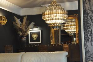 a bedroom with a large chandelier and a bed at Tir y Coed Country House in Conwy