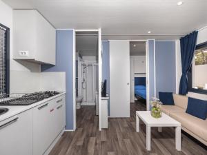 een keuken en een woonkamer met een bank en een tafel bij Anxur Village Camping in Terracina