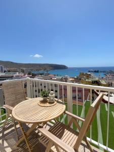 a table and chairs on a balcony with a view of the ocean at Apartamentos Ohana - Edificio Tonillo in Los Cristianos