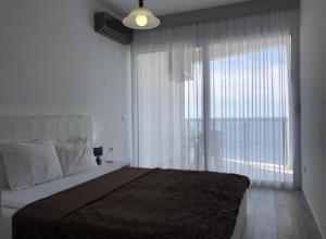 a bedroom with a large bed and a large window at Paradise beachfront view 2 in Dobra Voda