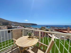 a table and chairs on a balcony with a view of the ocean at Apartamentos Ohana - Edificio Tonillo in Los Cristianos