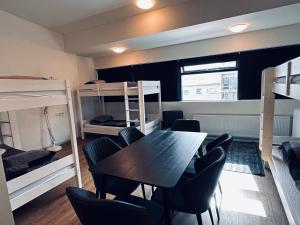 um quarto com uma mesa, cadeiras e beliches em Guesthouse Pavi em Reykjavík