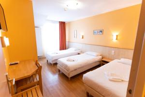 a hotel room with three beds and a table at Azureva Métabief in Métabief