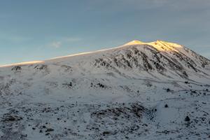 una montaña cubierta de nieve con el sol brillando sobre ella en Tec/Tea Pedrous, en Pas de la Casa