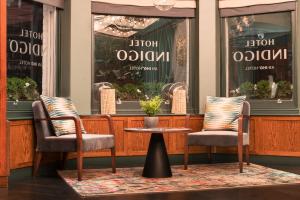 two chairs and a table in front of a store at Hotel Indigo London - Kensington, an IHG Hotel in London