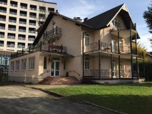 a large white house with balconies and a building at Hotel Sani in Truskavets