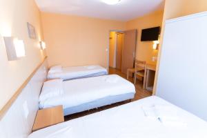 a hotel room with two beds and a desk at Azureva Métabief in Métabief