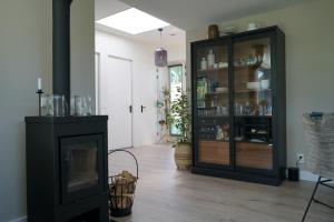 Texel Boogaloo في دي كوخ: غرفة معيشة مع موقد وخزانة سوداء