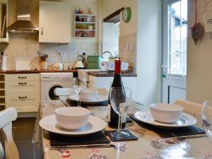 Llandegla的住宿－Bellringers Cottage, Llandegla，厨房配有带玻璃杯的桌子和一瓶葡萄酒
