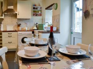 a kitchen with a table with glasses and a bottle of wine at Bellringers Cottage, Llandegla in Llandegla