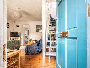 a hallway with a blue door and a living room at Pass the Keys Cottage with garden tucked away in central Exeter in Exeter
