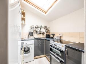 a kitchen with a washer and dryer at Pass the Keys Cottage with garden tucked away in central Exeter in Exeter