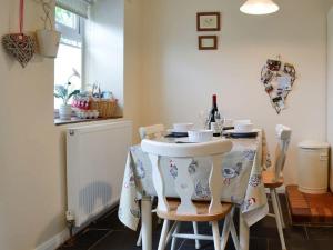 a kitchen with a table with a table cloth on it at Bellringers Cottage, Llandegla in Llandegla +8 photos