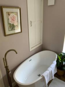 a white bath tub in a bathroom with a mirror at A beautiful 1 bedroom home. in Matlock