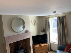 a living room with a fireplace and a mirror at A beautiful 1 bedroom home. in Matlock