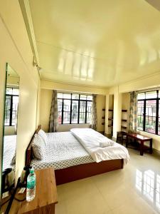 a bedroom with a bed in a room with windows at HEEMSTEDE in Shillong