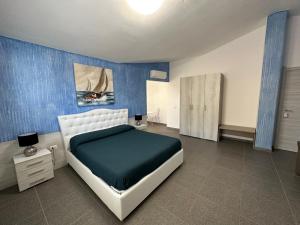 1 dormitorio con cama y pared azul en LXR Rooms Carloforte en Carloforte