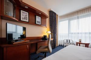 a hotel room with a bed and a desk with a television at stays by friends Gelsenkirchen in Gelsenkirchen