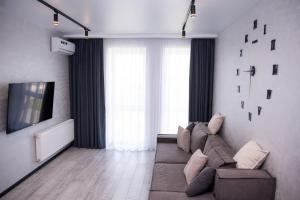 un soggiorno con divano e TV di Дизайнерські апартаменти в ЖК DreamTown 10а a Luc'k