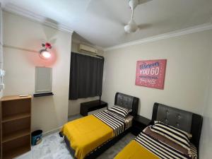 a bedroom with two beds and a sign on the wall at MY HOMESTAY BAHAU in Bahau