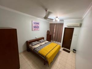 a bedroom with a bed with a yellow blanket at MY HOMESTAY BAHAU in Bahau