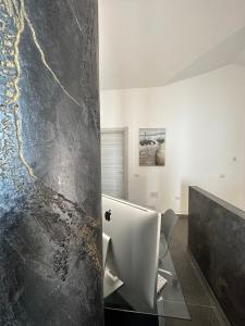 a bathroom with a black and white marble wall at LXR Rooms Carloforte in Carloforte