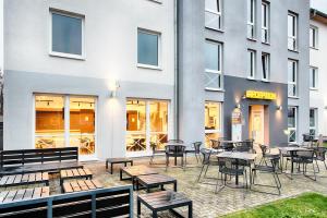 a patio with tables and chairs in front of a building at B&B Hotel Kassel-Süd in Kassel
