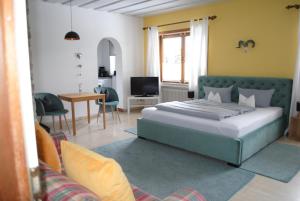 a bedroom with a bed and a living room at Landhaus Steinbrech in Grainau