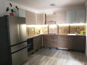 eine Küche mit Holzböden und Küchengeräten aus Edelstahl in der Unterkunft Apartment Bilic in Fažana