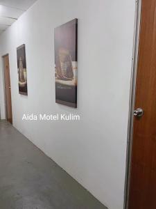 una pared con algunas fotos en una pared en Art Motel Kulim en Kulim