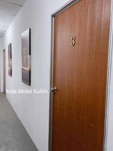 a wooden door with the number three on it at Art Motel Kulim in Kulim